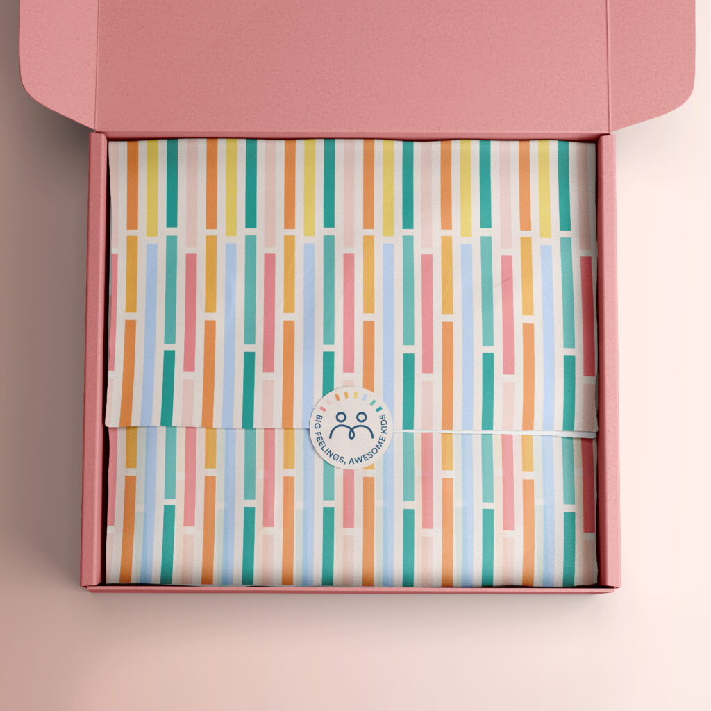 Open box with a branded pattern tissue paper and a custom sticker design for Big Feelings, Awesome Kids.