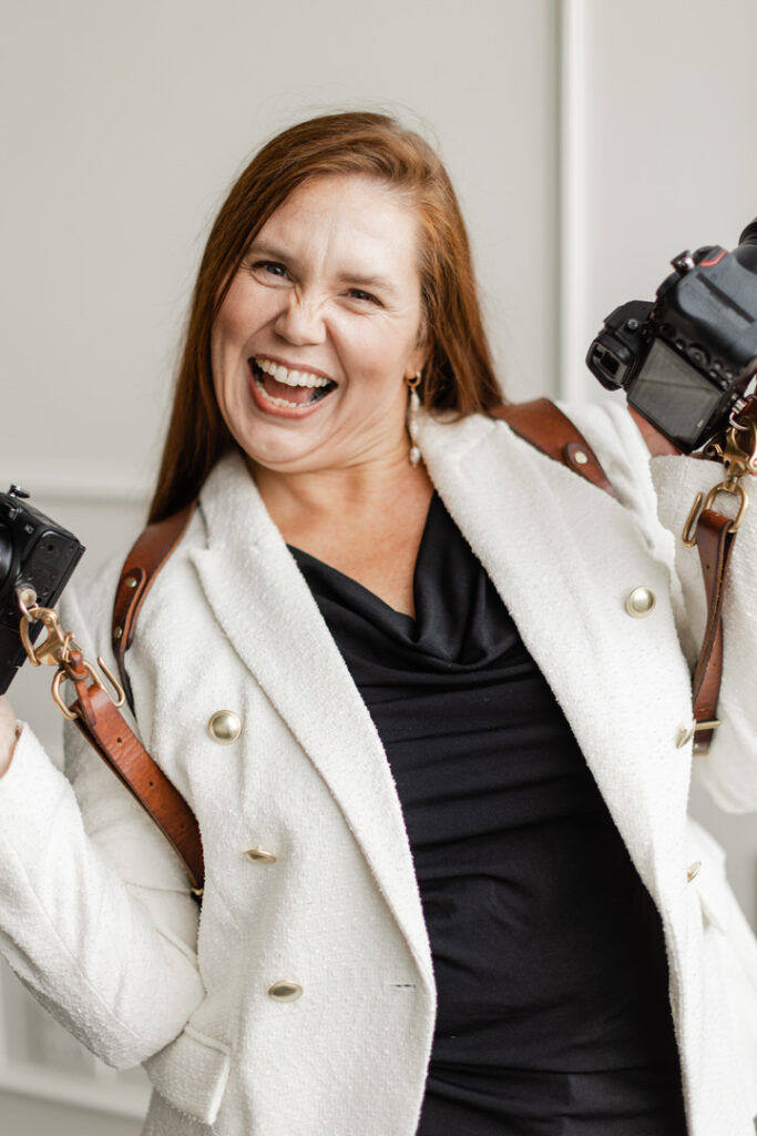 Lindsay Newton, an Oregon-based high school senior photographer holding up two cameras